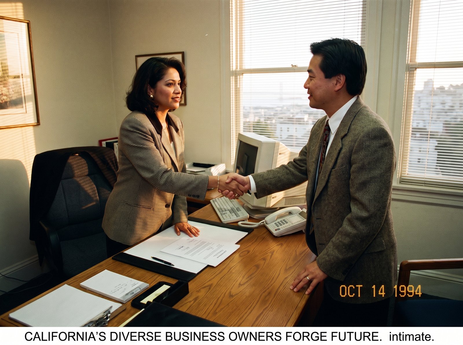California diverse business owners signing a contract mid-1990s, two business owners shaking hands across a desk, late afternoon light, archival editorial style, the working practice of supplier diversity.
